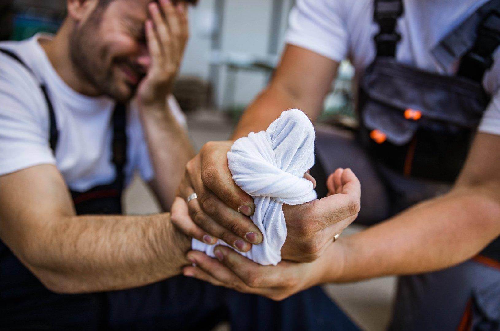 A male worker who has been injured on the job bandaging his hand in Forest Park, Georgia